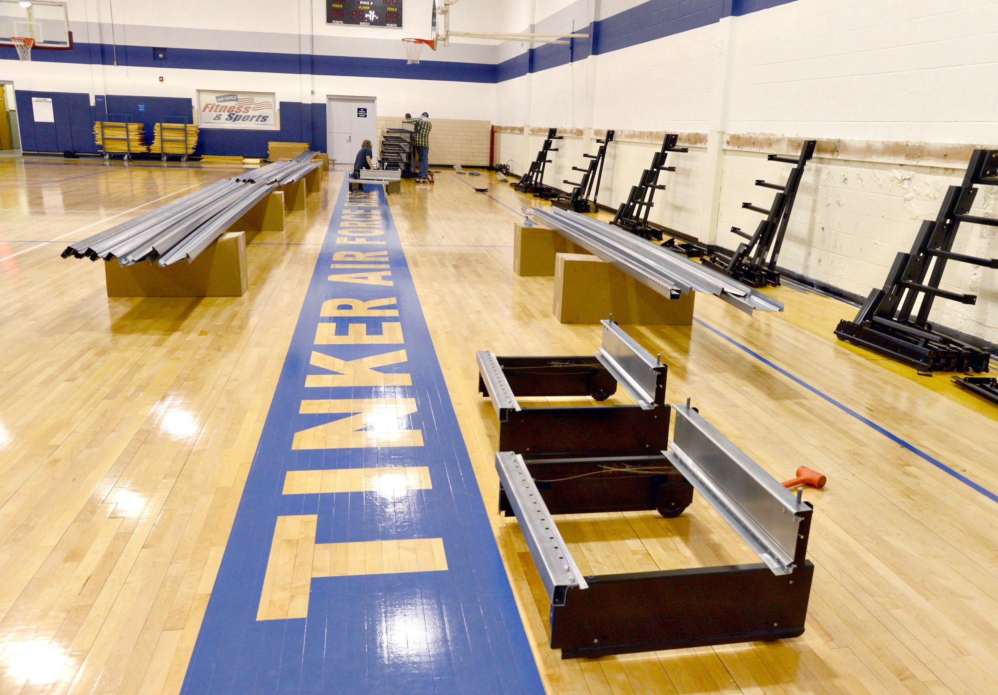 Construction workers from Oklahoma Automatic Door Company Inc. installed new bleachers inside the Gerrity Gym this week. The blue bleachers will match the new paint inside the basketball gym area. The $41,000 project was one of many upgrades the Gerrity has received recently. (Air Force photo by Kelly White/Released)