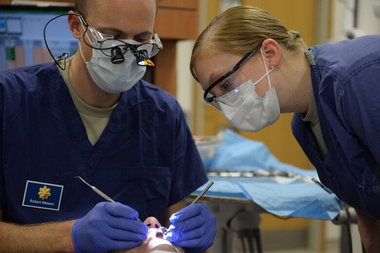 Senior Airman Alicia Rosdahl, a dental technician with the 423rd Medical Squadron, watches as Maj. Robert Watson, a dentist with the 423rd MDS, shows her a more efficient way to adjust the wire on a patient’s braces, during a checkup at the RAF Alconbury Dental Clinic, Jan. 6, 2015, at the dental clinic on RAF Alconbury. Rosdahl continually tries to gain as much experience as possible, with the goal of one day becoming a dentist herself. (U.S. Air Force photo by Airman 1st Class Zachary Bumpus/Released)