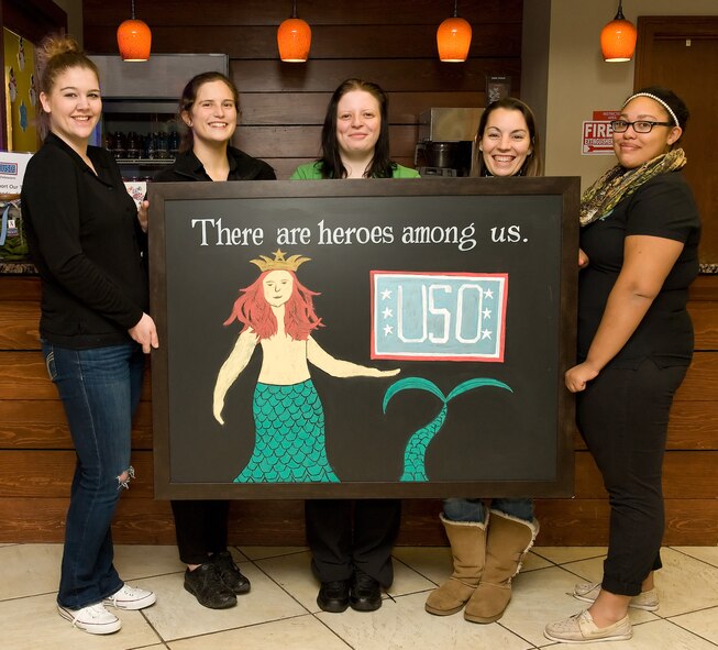 Paige Henry, barista; Kayla Rodgers and Amanda Hurley, both supervisors; Erika Endlein, store manager; and Tyler Craig, barista; left to right respectively, all Starbucks partners from the Dover, Del. location, hold a hand-drawn sign Jan. 7, 2016, at the USO Lounge on Dover Air Force Base, Del. Partners at the Dover location, the 13th Starbucks store designated as a military family store, delivered a coffee brewer and consumables to the USO Delaware lounge located in the Dover AFB passenger terminal and is now the second USO lounge in the United States to serve coffee within a USO. (U.S. Air Force photo/Roland Balik)