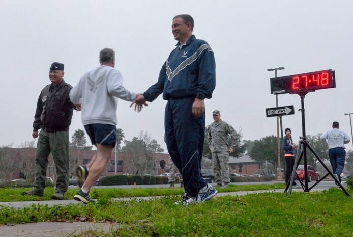 As Chief Master Sgt. Kristopher Berg, 437th Airlift Wing command chief, crosses the finish line he is greeted by Colonel Jimmy Canlas, 437th AW vice commander (left) and Colonel John Lamontagne, 437th AW commander, during the 437th AW 50th anniversary 5K on Joint Base Charleston – Air Base, S.C., Jan. 8, 2016. The first man to finish the 5K was 1st Lt. John Montes, 437th Aerial Port Squadron section commander, with a time of 17:30. (U.S. Air Force photo/Airman 1st Class Thomas T. Charlton)