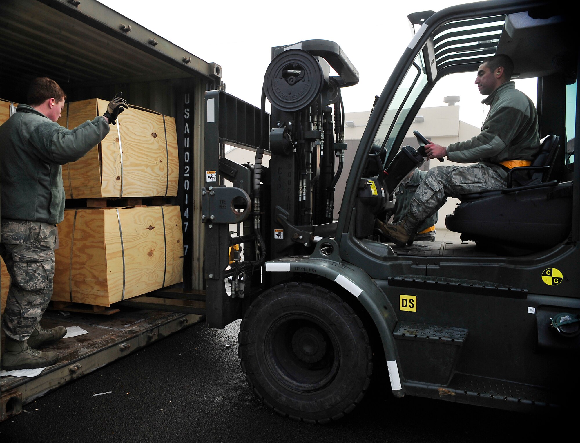 Senior Airman David Dean, 86th Munitions Squadron storage crew chief, directs Airman 1st Class Brandon Bradford, 86th MUNS munitions storage crew member, to remove munitions from a container Dec. 8, 2015, at Ramstein Air Base, Germany. The 86th MUNS Airmen handle armaments that are sent to deployed locations and NATO partners. (U.S. Air Force photo/Airman 1st Class Larissa Greatwood) 