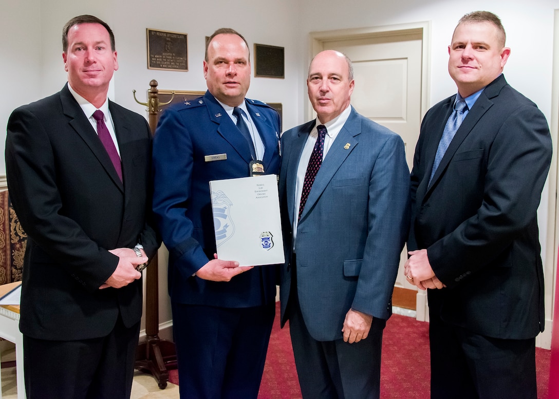 Brig. Gen. Keith M. Givens, Air Force Office of Special Investigations commander and Mr.Jeffrey Specht, OSI executive director, accept financial donations from the Federal Law Enforcement Officer Association Foundation, through the engagement of the Coast Guard Investigative Service, to benefit the families of four Fallen Heroes killed in the Dec. 21 suicide bomber attack near Bagram Air Field, Afghanistan. Presenting the checks Jan. 7 are Mr. Jason Wimer, far right, Special Agent in Charge of the CGIS Washington Field Office and CGIS Agency President for FLEOA, and Michael Berkow, second from right, Director of CGIS. (U.S. Air Force Photo by Michael Hastings)       