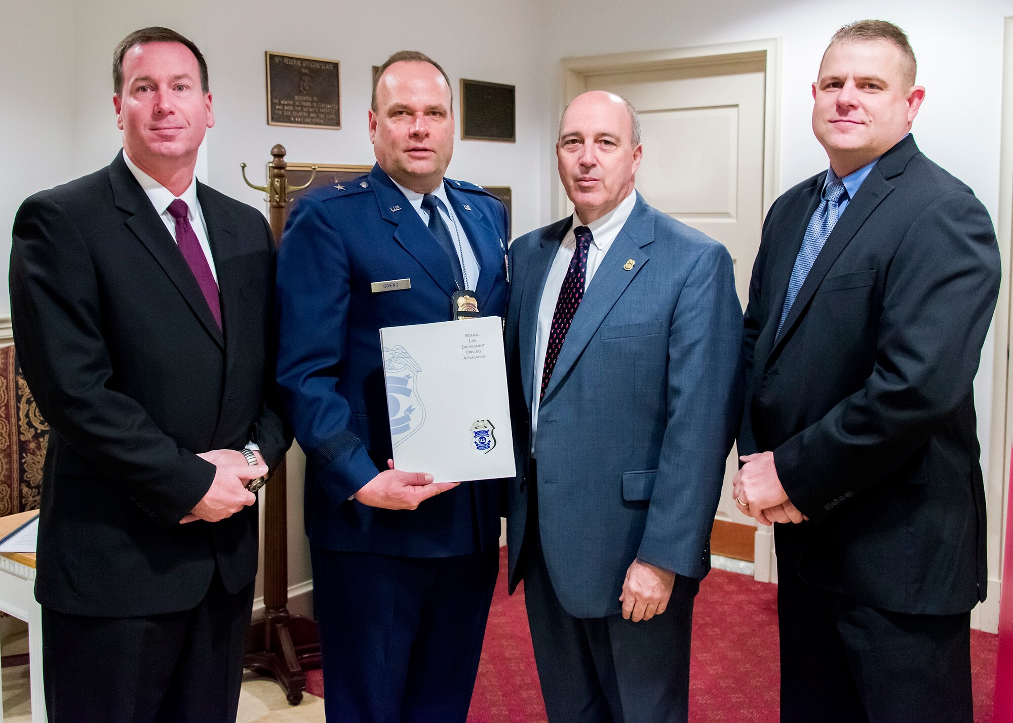 Brig. Gen. Keith M. Givens, Air Force Office of Special Investigations commander and Mr.Jeffrey Specht, OSI executive director, accept financial donations from the Federal Law Enforcement Officer Association Foundation, through the engagement of the Coast Guard Investigative Service, to benefit the families of four Fallen Heroes killed in the Dec. 21 suicide bomber attack near Bagram Air Field, Afghanistan. Presenting the checks Jan. 7 are Mr. Jason Wimer, far right, Special Agent in Charge of the CGIS Washington Field Office and CGIS Agency President for FLEOA, and Michael Berkow, second from right, Director of CGIS. (U.S. Air Force Photo by Michael Hastings)       