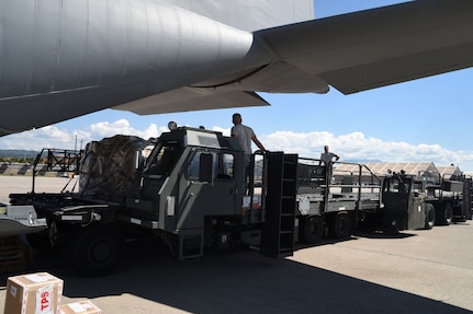 U.S. Air Force members assigned to the 612th Air Base Squadron unload cargo from a U.S. Air Force C-130J Super Hercules cargo aircraft on Soto Cano Air Base, Honduras, Jan. 7, 2016. The cargo was delivered  by use of the Denton Program, a program created to allow donated humanitarian goods the ability to use space available on military cargo aircraft. (U.S. Air Force photo by Martin Chahin/Released)