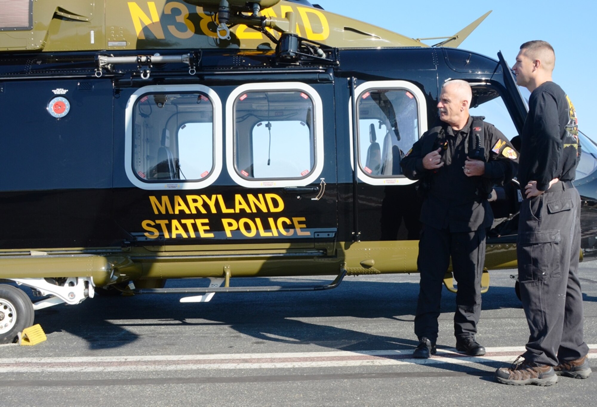 Tech. Sgt. Timothy Dash talks to a Maryland State Police Helicopter pilot prior to a flight at Martin State Airport in Baltimore December 4th. Dash is the 175th Wing Spotlight Airman for January 2016. In his civilian job, Dash is a Maryland State Police helicopter mechanic. (U.S. Air National Guard photo by Tech. Sgt. David Speicher/RELEASED)
