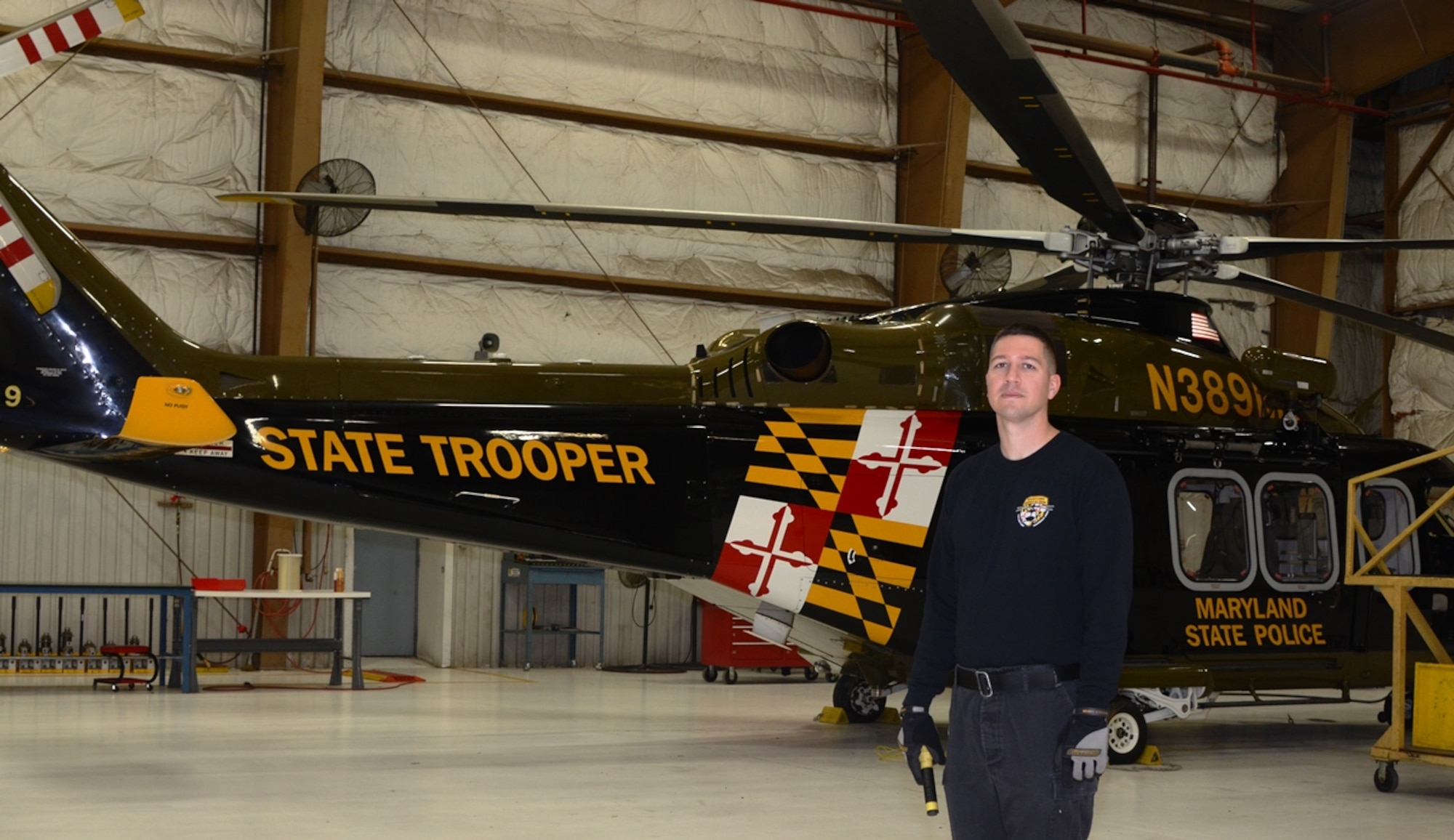 Tech. Sgt. Timothy Dash stands in front of a Maryland State Police Helicopter at Martin State Airport in Baltimore December 4th. Dash is the 175th Wing Spotlight Airman for January 2016. In his civilian job, Dash is a Maryland State Police helicopter mechanic. (U.S. Air National Guard photo by Senior Master Sgt. Ed Bard/RELEASED)
