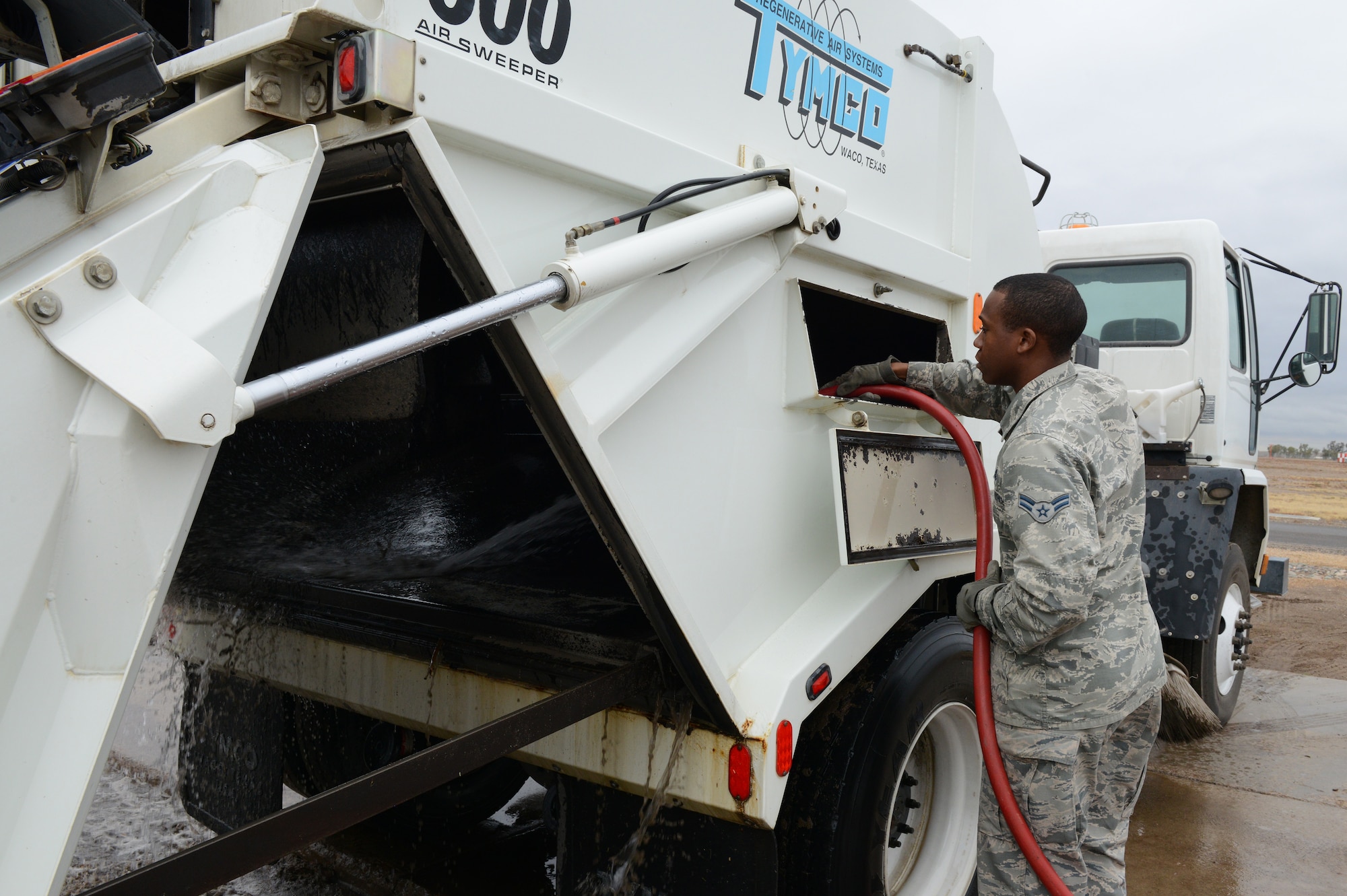 Airman 1st Class Demetrius Smith, 56th Civil Engineer Squadron heavy equipment operator, washes a street sweeper at Luke Air Force Base, Ariz., Jan. 5, 2016. Street sweepers are used more often after storms hit the base to help clean the streets. (U.S. Air Force photo by Senior Airman James Hensley)