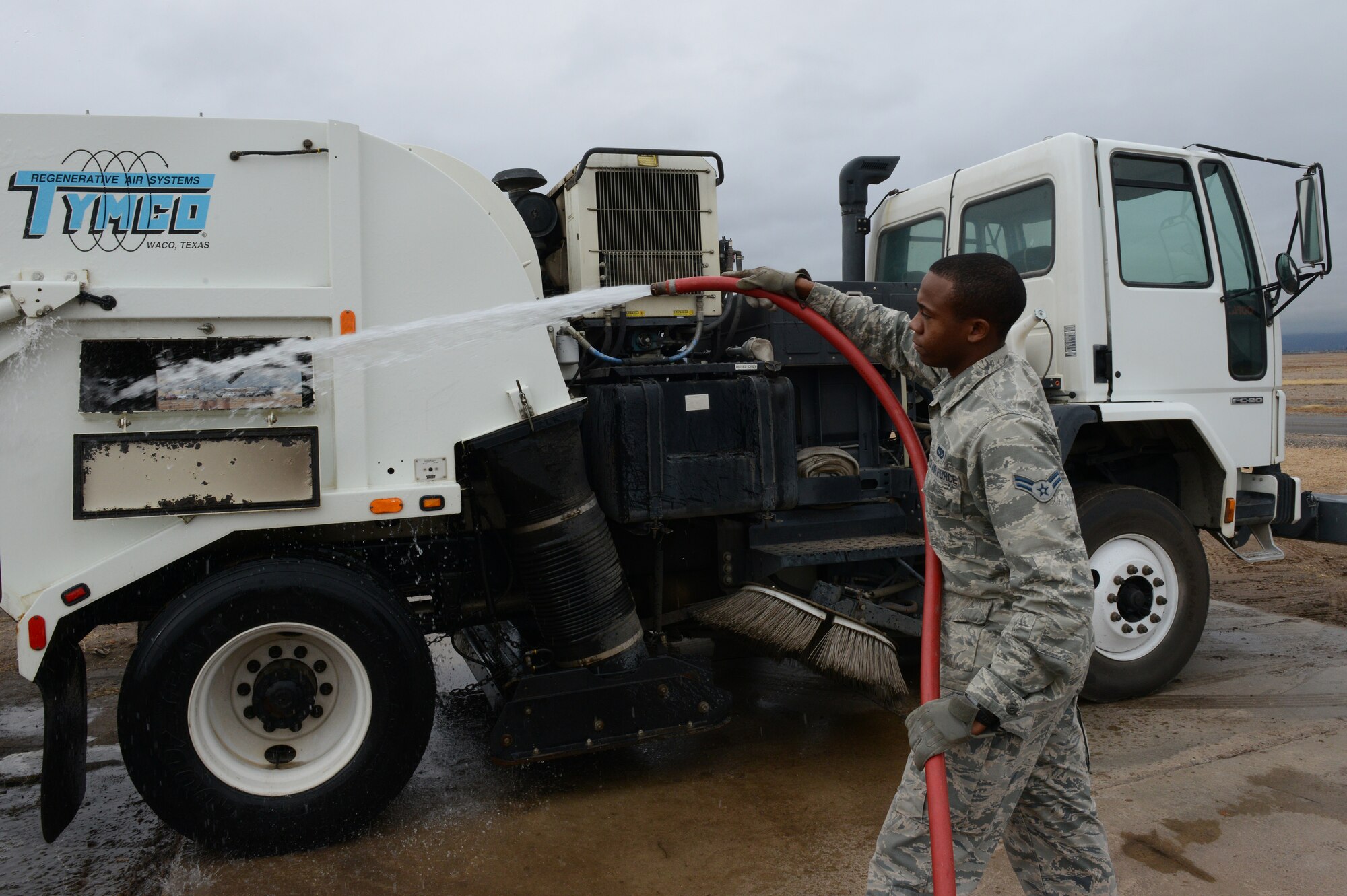 Airman 1st Class Demetrius Smith, 56th Civil Engineer Squadron heavy equipment operator, washes the exterior of a street sweeper at Luke Air Force Base, Ariz., Jan. 5, 2016. (U.S. Air Force photo by Senior Airman James Hensley)