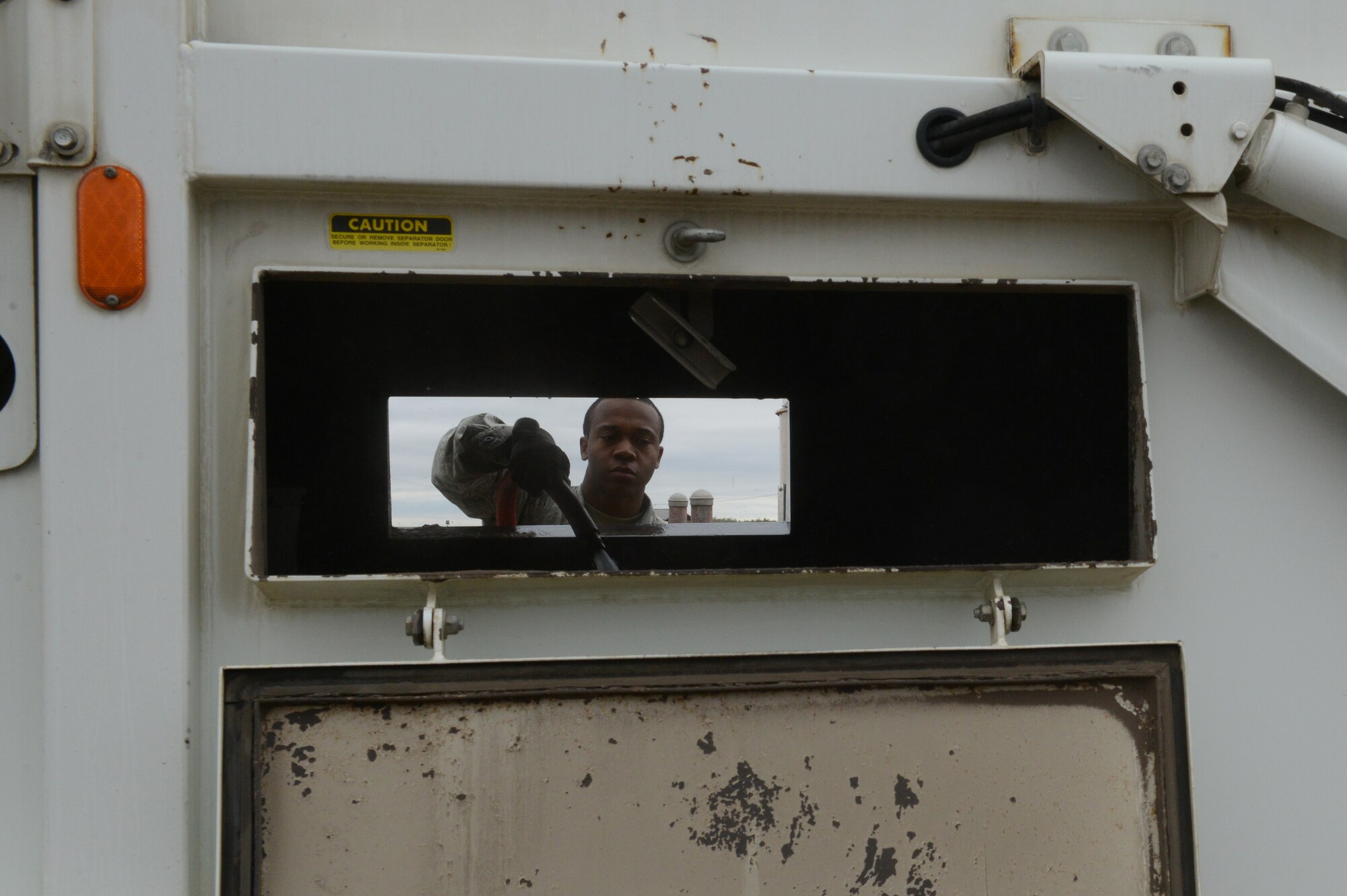 Airman 1st Class Demetrius Smith, 56th Civil Engineer Squadron heavy equipment operator, sprays the inside of a street sweeper while cleaning it at Luke Air Force Base, Ariz., Jan. 5, 2016. (U.S. Air Force photo by Senior Airman James Hensley)