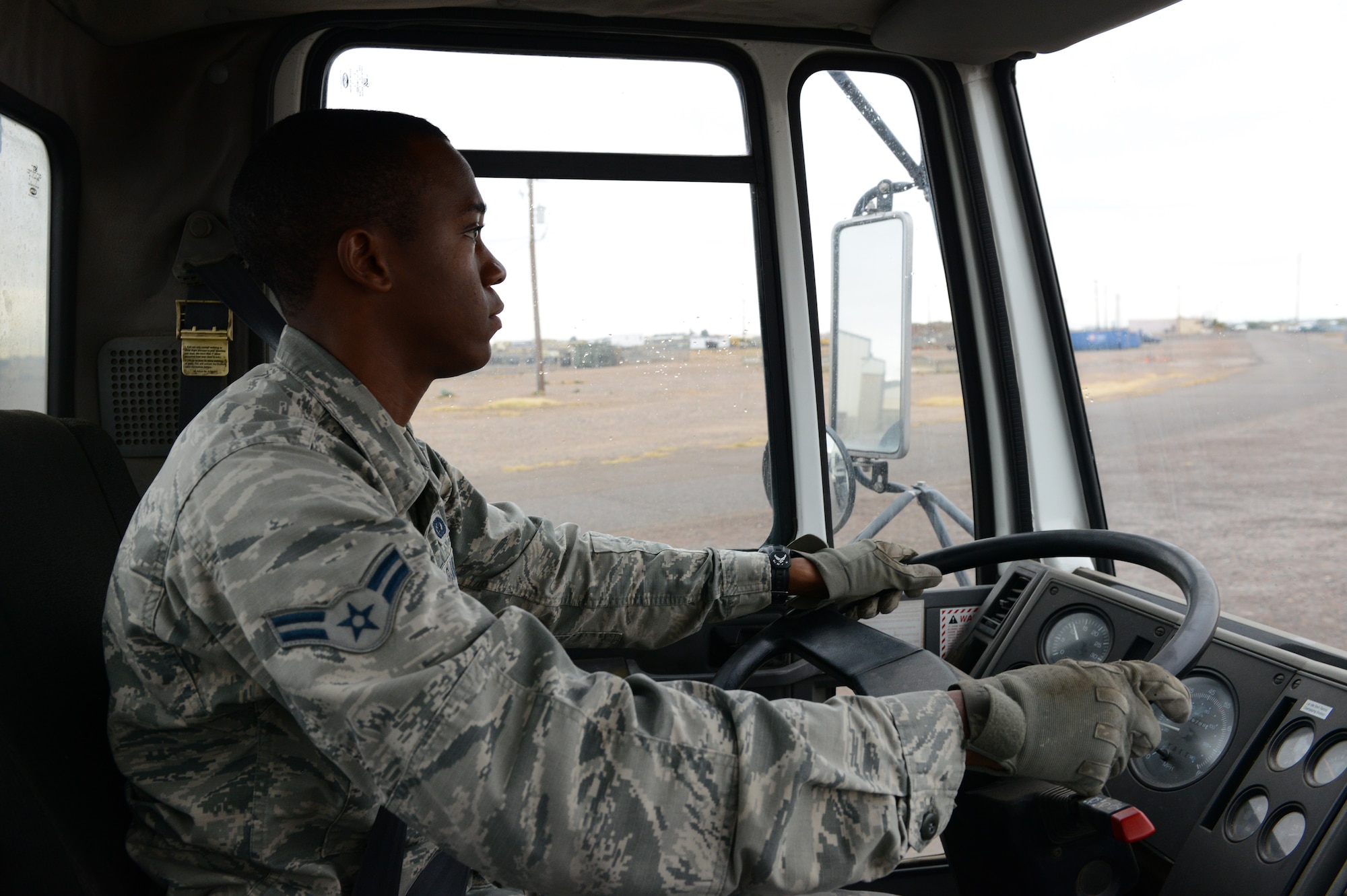 Airman 1st Class Demetrius Smith, 56th Civil Engineer Squadron heavy equipment operator, drives a street sweeper along perimeter road at Luke Air Force Base, Ariz., Jan. 5, 2015. Street sweeping, heavy equipment movement and excavators for trenches are utilized to assist various jobs around the base and 56th CES. (U.S. Air Force photo by Senior Airman James Hensley)