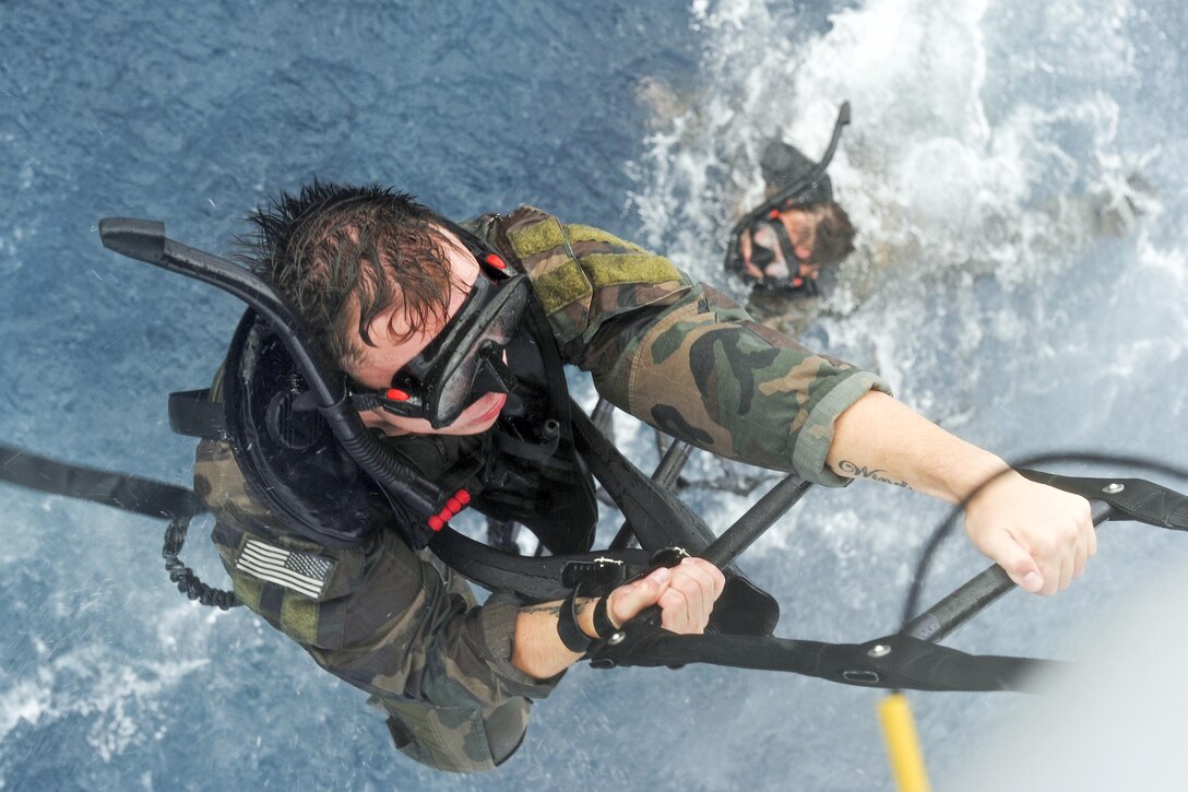 A U.S. Marine climbs the ladder to an MH-60S Knighthawk helicopter assigned to Helicopter Sea Combat Squadron 25 during a helo-cast off the coast of Guam, Jan. 6, 2016. U.S. Navy photo by Petty Officer 2nd Class Chelsy Alamina