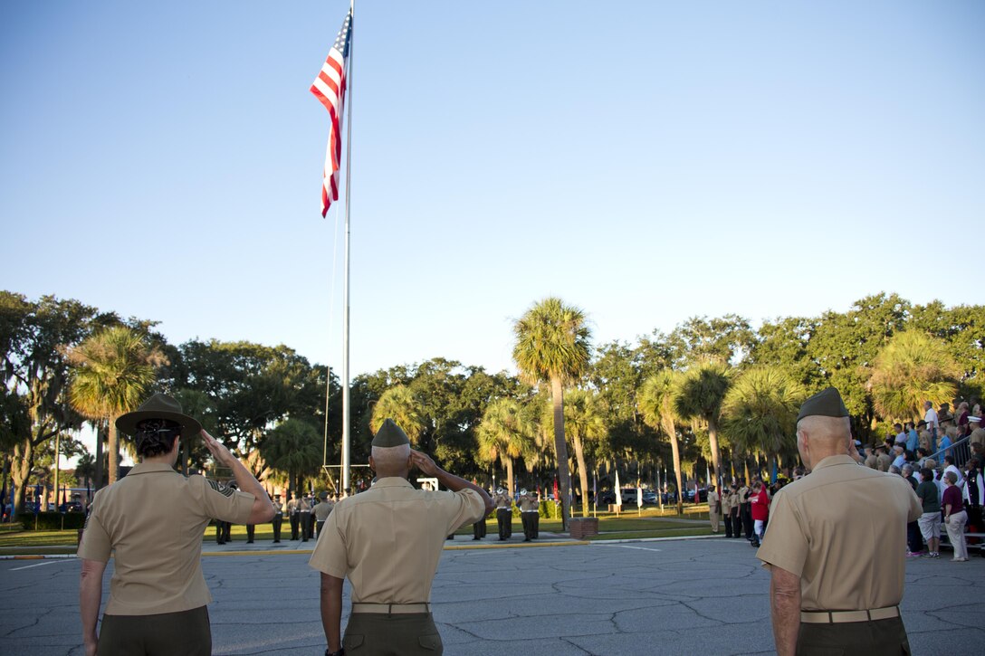 U.S. Marines Sgt. Maj. Angela M. Maness, left, the sergeant major, Brig. Gen. Terry V. Williams, center, the commanding general, both of Marine Corps Recruit Depot (MCRD) Parris Island (PI), and Commandant of the Marine Corps, Gen. Robert B. Neller, salute the American flag during morning colors at MCRD PI, S.C., Oct. 16, 2015. Neller visited the depot to outline the Corps' current priorities, expectations, listen and answer questions. (U.S. Marine Corps photo by Sgt. Gabriela Garcia/Released)