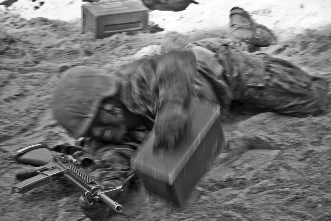 A recruit crawls with a rifle and ammunition can during the crucible at Marine Corps Recruit Depot Parris Island, S.C., Oct. 16, 2015. All Marine Corps recruits must go through the crucible as part of their recruit training. (U.S. Marine Corps photo illustration by Sgt. Gabriela Garcia/Released)