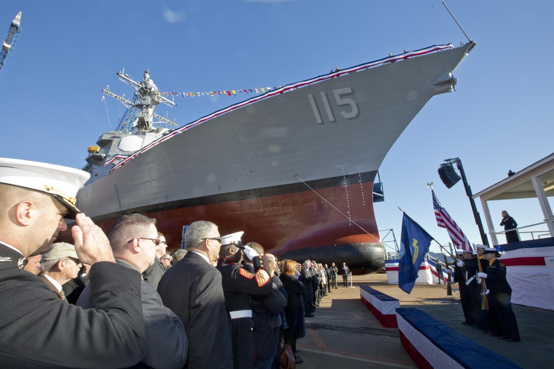 U.S. Marines, Sailors and guests honor the American and Navy flag during the USS Rafael Peralta christening ceremony at General Dynamics Bath Iron Works, Bath, Maine, Oct. 31, 2015. The destroyer was named after Marine Corps Sgt. Rafael Peralta who was killed during the second battle of Fallujah in 2004. (U.S. Marine Corps photo Sgt. Gabriela Garcia/Released)