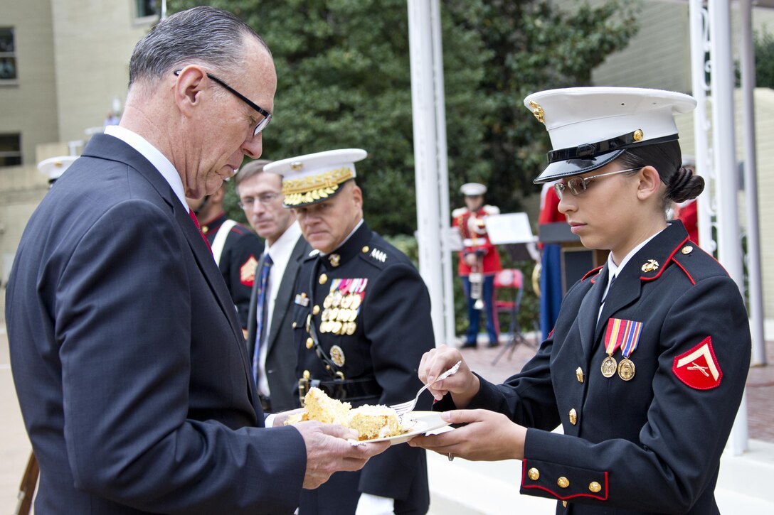 Retired U.S. Marine Corps Col. Jan Durham, the oldest Marine, passes the cake to the youngest Marine, Lance Cpl. Michelle N. Ponce, during the Pentagon cake cutting ceremony at Washington, D.C., Nov. 9, 2015. The ceremony celebrated the Corps' 240th birthday since it was first established on Nov. 10, 1775. (U.S. Marine Corps photo by Sgt. Gabriela Garcia/Released)