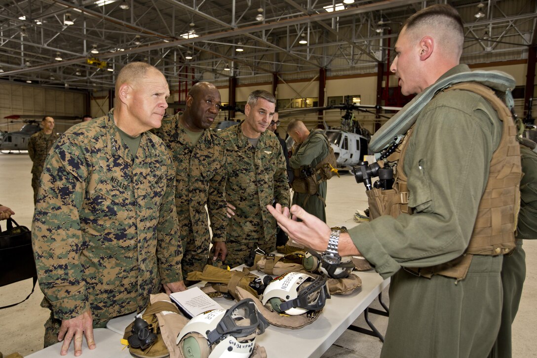 Commandant of the Marine Corps, Gen. Robert B. Neller, left, Sgt. Maj. of the Marine Corps Ronald L. Green, center and another Marine listen to a Marine before touring the Oahu facilities at Hawaii, Nov. 20, 2015. Neller, Green and other Marines toured Oahu facilities from inside a UH-1Y huey aircraft during their Hawaii visit. (U.S. Marine Corps photo by Staff Sgt. Gabriela Garcia/Released)