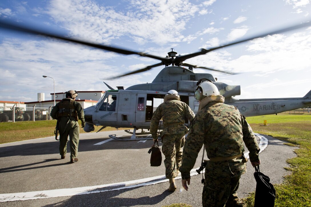 Commandant of the Marine Corps, Gen. Robert B. Neller, center, walks towards a UH-1Y Huey aircraft with Marine Light Attack Helicopter Squadron 167, during his visit with Marines at Kadena Air Force Base, Okinawa, Japan, Nov. 23, 2015. Neller visited with Marines to outline the Corps' current priorities, expectations, and answer Marines' questions. (U.S. Marine Corps photo by Staff Sgt. Gabriela Garcia/Released)