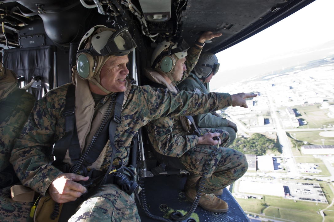 Commandant of the Marine Corps, Gen. Robert B. Neller, points from inside a UH-1Y Huey aircraft Marine Light Attack Helicopter Squadron 167, during his visit with Marines at Kadena Air Force Base, Okinawa, Japan, Nov. 23, 2015. Neller visited with Marines to outline the Corps' current priorities, expectations, and answer Marines' questions. (U.S. Marine Corps photo by Staff Sgt. Gabriela Garcia/Released)