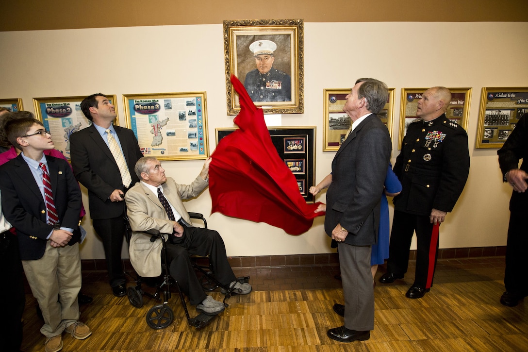 Commandant of the Marine Corps, Gen. Robert B. Neller, right, watches as a the Davis family unveils a portrait at Atlanta, Ga., Dec. 2, 2015. Neller was the guest of honor speaker at retired Gen. Raymond G. Davis's portrait unveiling ceremony inside the Floyd Veterans Memorial Building. (U.S. Marine Corps photo by Staff Sgt. Gabriela Garcia/Released)