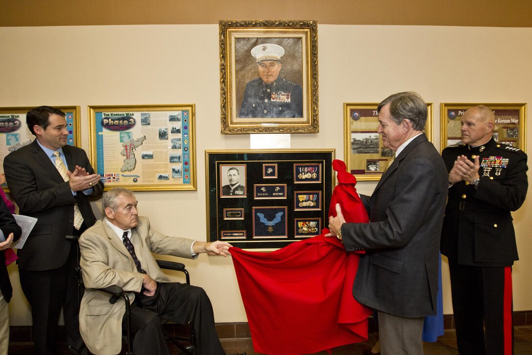 Commandant of the Marine Corps, Gen. Robert B. Neller, right, claps as a the Davis family unveils a portrait at Atlanta, Ga., Dec. 2, 2015. Neller was the guest of honor speaker at retired Gen. Raymond G. Davis's portrait unveiling ceremony inside the Floyd Veterans Memorial Building. (U.S. Marine Corps photo by Staff Sgt. Gabriela Garcia/Released)