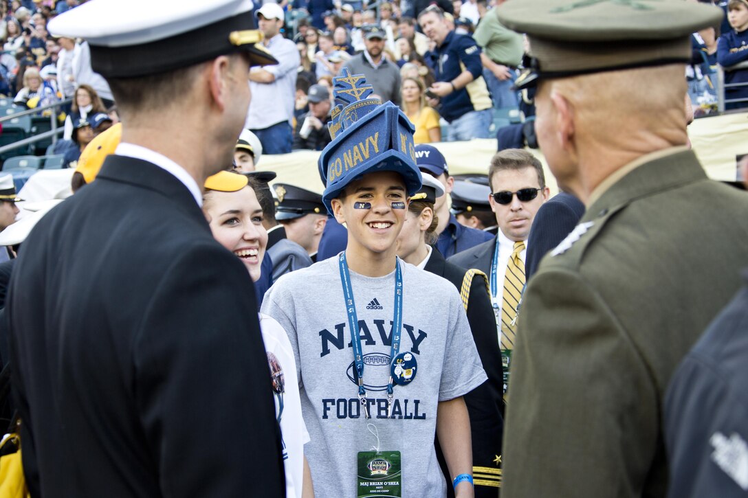 Commandant of the Marine Corps, Gen. Robert B. Neller, right, greets Chief of Naval Operations Adm. John Richardson's, left, family during the Army-Navy game at Lincoln Financial Field in Philadelphia, Pa., Dec. 12, 2015. Neller and Richardson participated in the game's coin toss done by Secretary of Defense, Ashton B. Carter. (U.S. Marine Corps photo by Staff Sgt. Gabriela Garcia/Released)