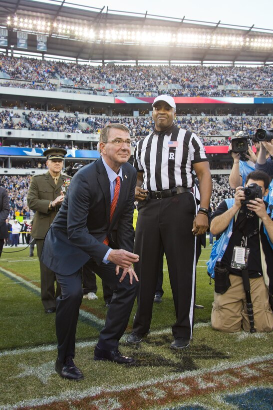 Commandant of the Marine Corps, Gen. Robert B. Neller, back left, watches Secretary of Defense, Ashton B. Carter, prepare for a coin toss at Philadelphia, Pa., Dec. 12, 2015. Neller participated in the Army-Navy game 's coin toss at Lincoln Financial Field. (U.S. Marine Corps photo by Staff Sgt. Gabriela Garcia/Released)