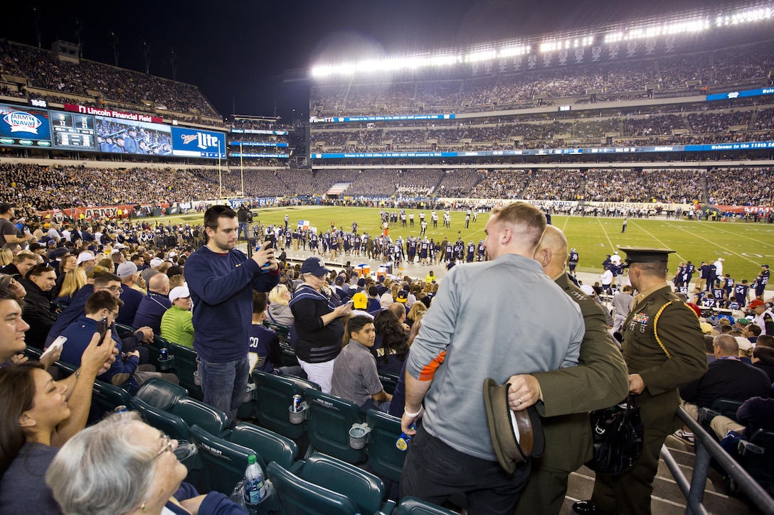 Commandant of the Marine Corps, Gen. Robert B. Neller takes pictures with fans of the Army-Navy game at Lincoln Financial Field in Philadelphia, Pa., Dec. 12, 2015. Neller participated in the game's coin toss done by Secretary of Defense, Ashton B. Carter. (U.S. Marine Corps photo by Staff Sgt. Gabriela Garcia/Released)