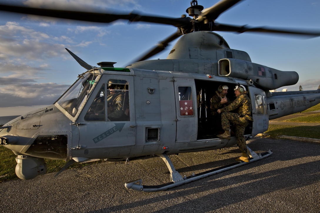 Commandant of the Marine Corps, Gen. Robert B. Neller, right, climbs inside a UH-1Y Huey aircraft with Marine Light Attack Helicopter Squadron 167, during his visit with Marines at Camp Foster, Okinawa, Japan, Nov. 23, 2015. Neller visited with Marines to outline the Corps' current priorities, expectations, and answer Marines' questions. (U.S. Marine Corps photo by Staff Sgt. Gabriela Garcia/Released)