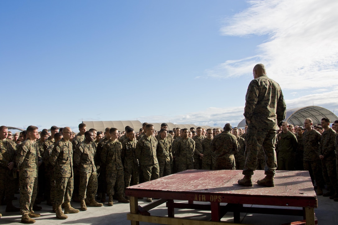 Commandant of the Marine Corps, Gen. Robert B. Neller, right, listens to Sgt. Maj. of the Marine Corps Ronald L. Green, back right, speak to Marines at Marine Corps Air Station Iwakuni, Okinawa, Japan, Nov. 24, 2015. Neller and Green outlined the Corps' current priorities, expectations, listened and answered Marines' questions. (U.S. Marine Corps photo by Staff Sgt. Gabriela Garcia/Released)