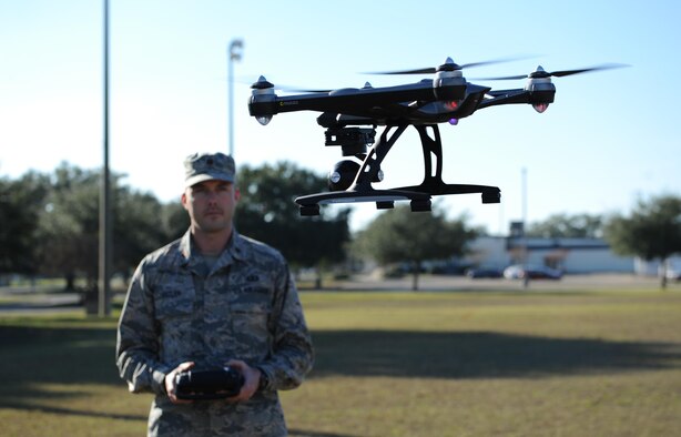 Maj. Joshua D. Pitler, 81st Operations Support Flight commander, operates an Unmanned Aerial System, more commonly known as a drone, Dec. 8, 2015, at Keesler Air Force Base, Miss. Drones are prohibited from being operated on base. For more information and guidance on the operation of UAS visit, www.FAA.gov/UAS/model_aircraft/ (U.S. Air Force photo by Kemberly Groue)