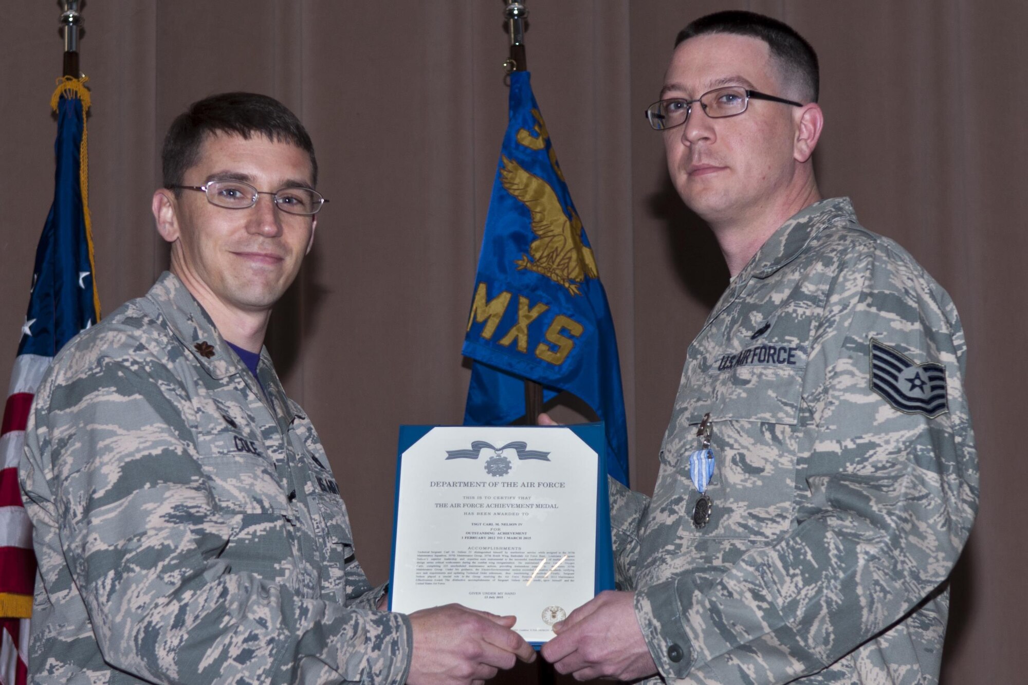 U.S Air Force Maj. George P. Cole III, 307th Maintenance Squadron commander, awards the Air Force Achievement Medal to Tech. Sgt. Carl M. Nelson IV on Jan. 09, 2015, Barksdale Air Force Base, La. Nelson received the award for superior leadership and expertise which led to the successful transformation of multiple work centers during the combat wing reorganization.  (U.S. Air Force photo by Senior Airman Callie Ware/Released)