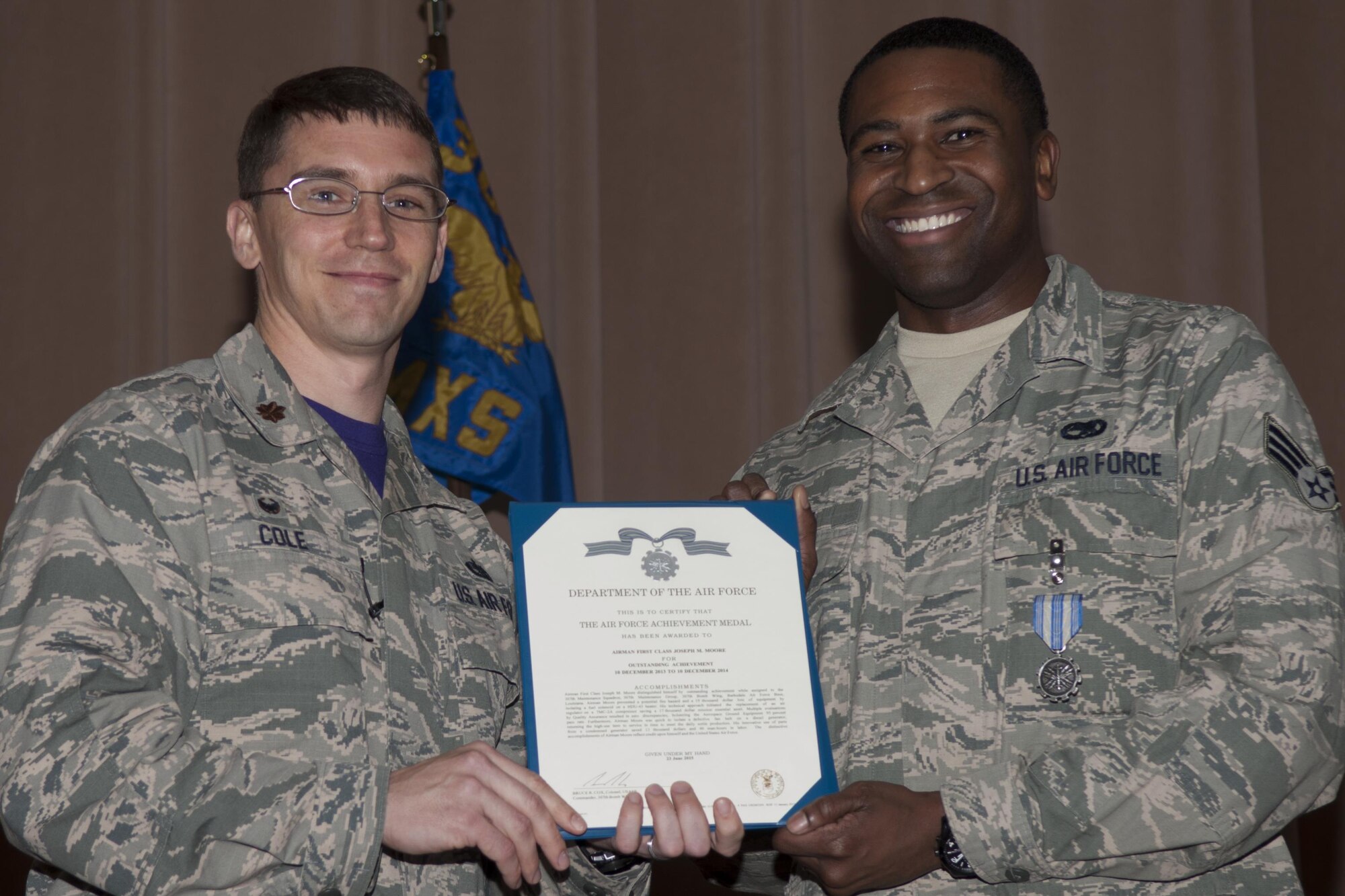 U.S Air Force Maj. George P. Cole III, 307th Maintenance Squadron commander, awards the Air Force Achievement Medal to Airman 1st Class Joseph M. Moore on Jan. 09, 2015, Barksdale Air Force Base, La. Moore was awarded for outstanding achievement in the prevention of potential fire hazards and loss of equipment.  His innovations saved thousands of dollars and hours of labor in the Aerospace Ground Equipment Flight.  (U.S. Air Force photo by Senior Airman Callie Ware/Released)