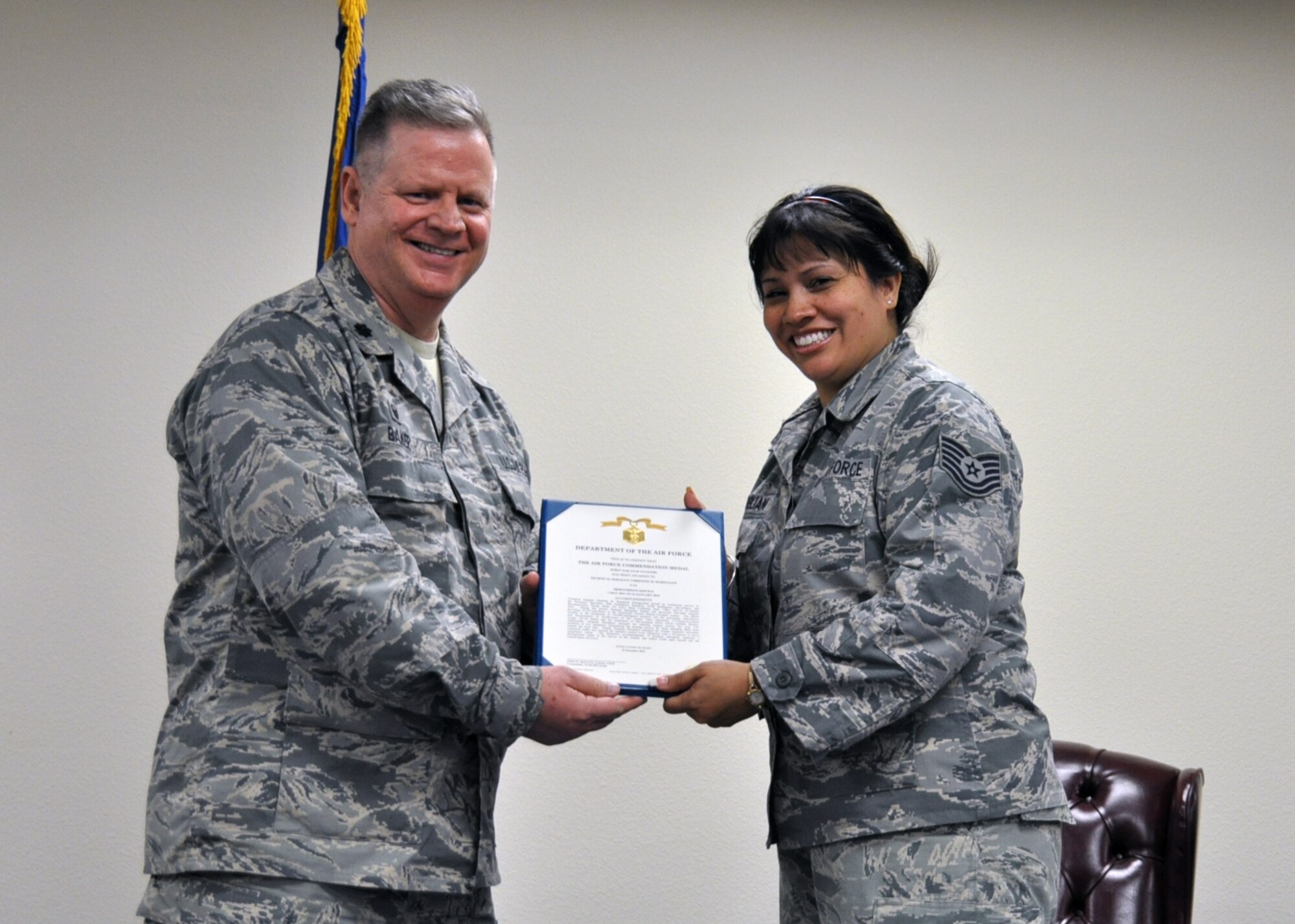 Lt. Col. Ralph Baker, 940th Aerospace Medicine Squadron commander, presents Tech. Sgt. Christine Marigliani, 50th Intelligence Squadron personnel member, with her retirement certificate, Jan. 9, at Beale Air Force Base, California. Marigliani served 20 years and was widely esteemed by her peers. (U.S. Air Force photo by Tech. Sgt. Skinkle/Released)