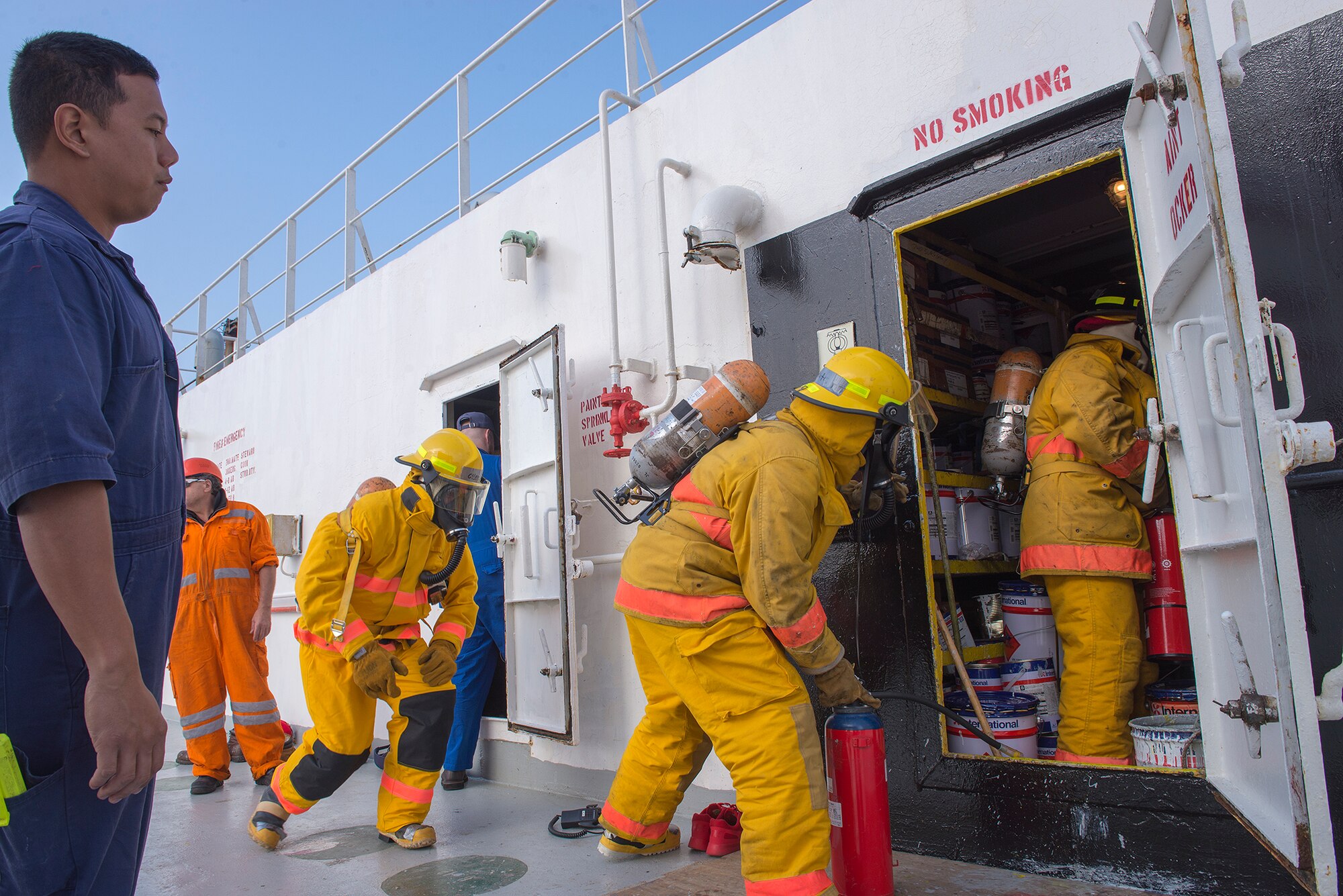 Lt. Kenn Yuen, Coast Guard Activities Far East marine inspector, observes U.S. flagged ship GREEN RIDGE crewmen as they perform a fire response drill, during an inspection at Yokohama, Japan, Dec. 16, 2015. The drill tested the crew's ability to don safety gear, use proper firefighting techniques and follow procedures. (U.S. Air Force photo by Senior Airman David C. Danford/Released)
