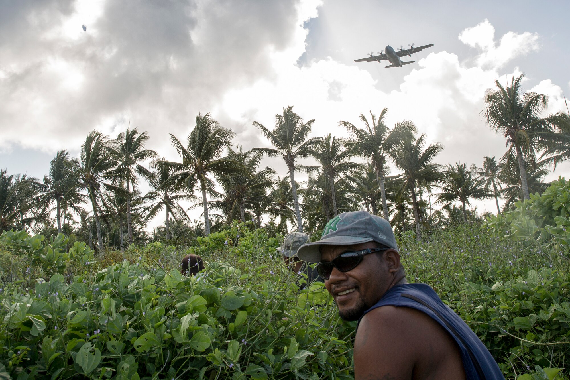 Islanders from Fais sit down to wait for the bundle drop during Operation Christmas Drop 2015, at Fais Island, Federated States of Micronesia, Dec. 8, 2015. A C-130 Hercules assigned to the 36th Airlift Squadron delivered over 800 pounds of supplies to the island of Fais during Operation Christmas Drop 2015. This year marks the first ever trilateral Operation Christmas Drop where the U.S. Air Force, Japan Air Self-Defense Force and the Royal Australian Air Force work together to provide critical supplies to 56 Micronesian islands. (U.S. Air Force photo by Osakabe Yasuo/Released) 