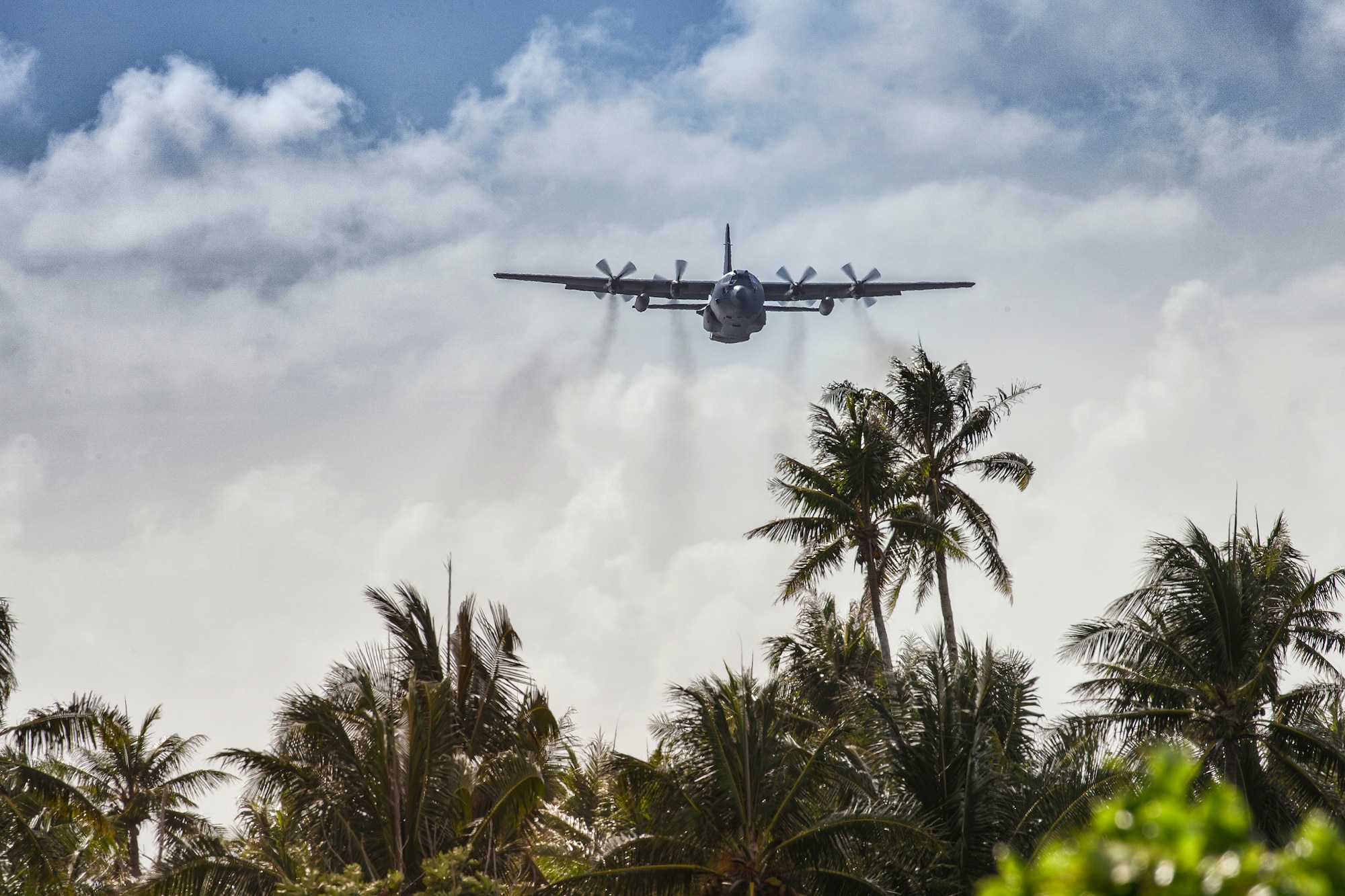 A C-130 Hercules from the 36th Airlift Squadron flies over Fais Island, Dec. 8, 2015, during Operation Christmas Drop 2015. Airmen from the Yokota delivered over 800 pounds of supplies to the island of Fais during Operation Christmas Drop 2015. This year marks the first ever trilateral Operation Christmas Drop where the U.S. Air Force, Japan Air Self-Defense Force and the Royal Australian Air Force work together to provide critical supplies to 56 Micronesian Islands. (U.S. Air Force photo by Osakabe Yasuo/Released) 