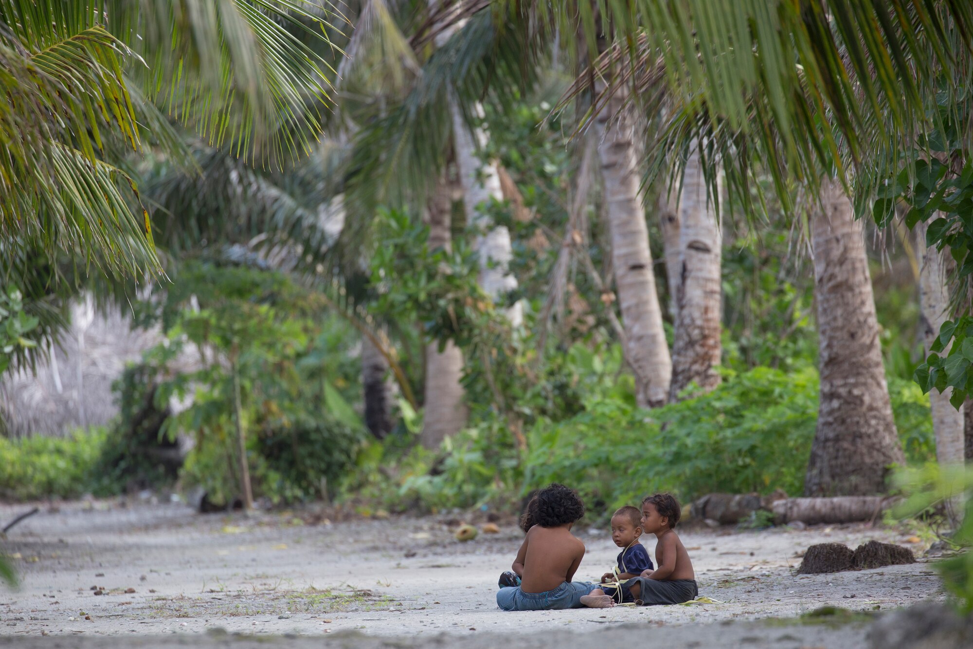 Kids sit under shade at Fais Island, Federated Sates of Micronesia, Dec. 8, 2015, during Operation Christmas Drop 2015. A C-130 Hercules from the 36th Airlift Squadron delivered more than 800 pounds of supplies to Fais island during Operation Christmas Drop 2015. This year marks the first trilateral execution that includes air support from the Japan Air-Self Defense force and the Royal Australian Air Force. (U.S. Air Force photo by Osakabe Yasuo/Released)
