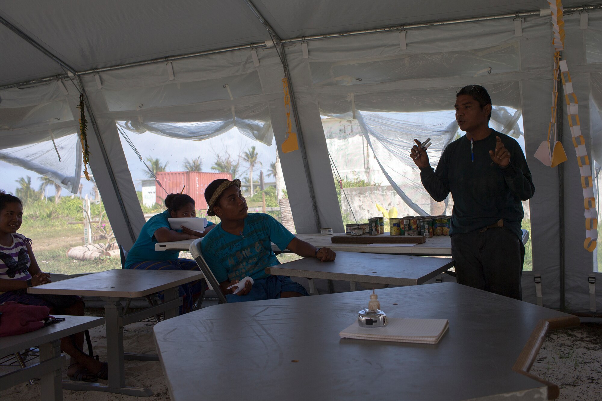 Stephen Mara, right, teaches an agriculture class at a temporary classroom tent, donated by International Organization for Migration Micronesia at Outer Islands High School, Falalop Island, Ulithi Atoll, Federated States of Micronesia. Most of educational facility was devastated by Typhoon Maysak in March 2015. (U.S. Air Force photo by Osakabe Yasuo/Released) 