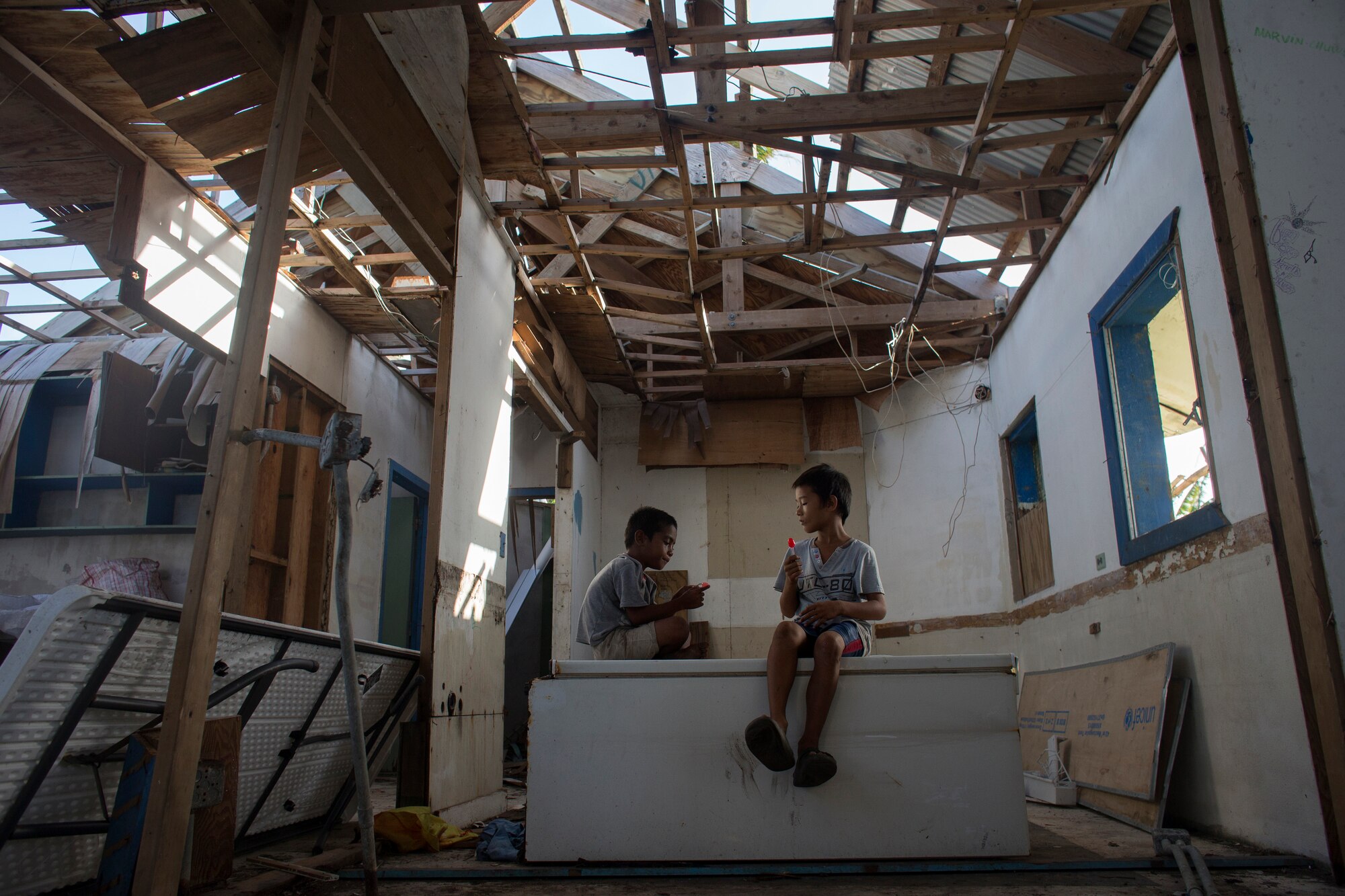 Children sit at damaged school building at Falalop Island, Ulithi Atoll, Federated States of Micronesia, Dec. 7, 2015. Most of educational facility was devastated by Typhoon Maysak in March 2015. (U.S. Air Force photo by Osakabe Yasuo/Released) 