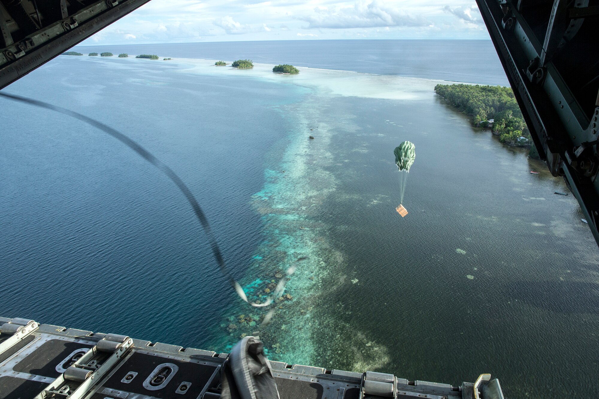 A low-cost low-altitude bundle of donated goods drops to Lukunor Atoll, Federated States of Micronesia, Dec. 9, 2015, during Operation Christmas Drop. This year marks the 64th year of Operation Christmas Drop, which began in 1952, making it the world's longest-running airdrop mission. This is the first ever trilateral training event that includes additional air support from Japan Air Self-Defense Force and Royal Australian Air Force C-130 aircrews. (U.S. Air Force photo by Osakabe Yasuo/Released)
