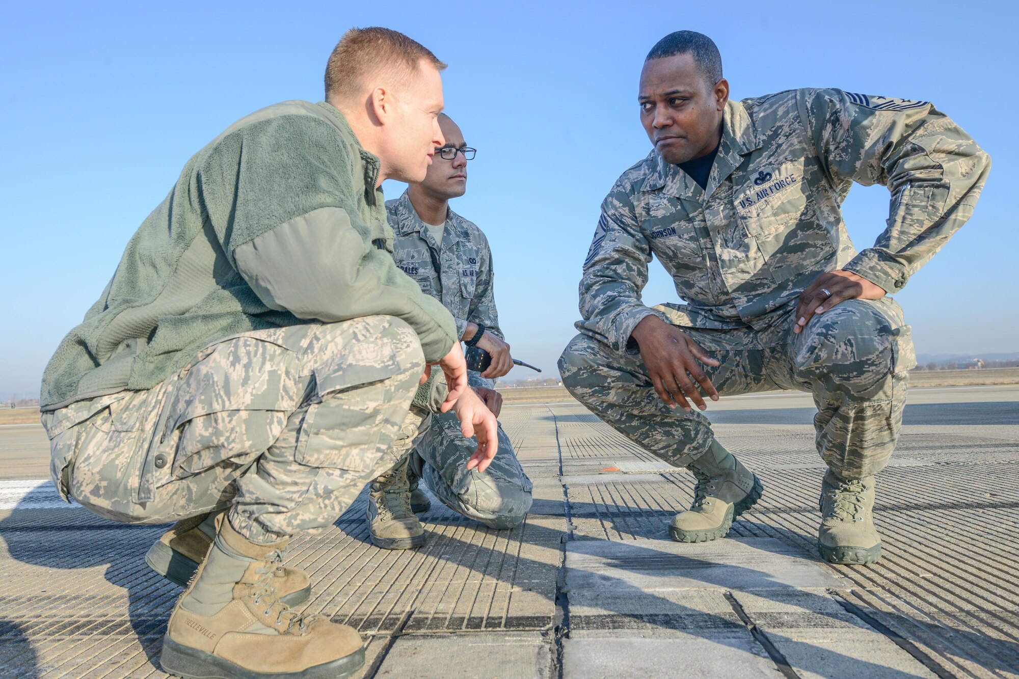 Lt. Col. Jason Jensen, 51st OSS commander, and Staff Sgt. David Morales, 51st Operation Support Squadron airfield management operations supervisor, speak with Seventh Air Force Command Chief Master Sgt. Anthony Johnson on the flightline during the chief’s 51st Operations Group immersion at Osan Air Base, Republic of Korea, Jan. 8, 2016. Morales explained processes in keeping the flightline mission ready. (U.S. Air Force photo/Airman 1st Class Dillian Bamman)