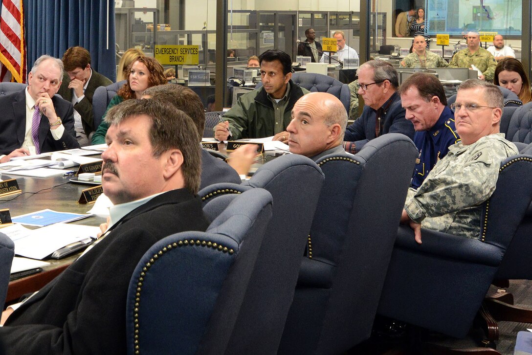 Army Maj. Gen. Glenn H. Curtis, center right, adjutant general of the Louisiana National Guard, joins Louisiana Gov. Bobby Jindal, center, Governor-elect John Bel Edwards, left, and other officials in a command group meeting to discuss plans to protect people and property from expected river flooding at the Governor’s Office of Homeland Security and Emergency Preparedness’ Emergency Operations Center in Baton Rouge, La., Jan. 8, 2016. Louisiana Army National Guard photo by Spc. Joshua Barnett