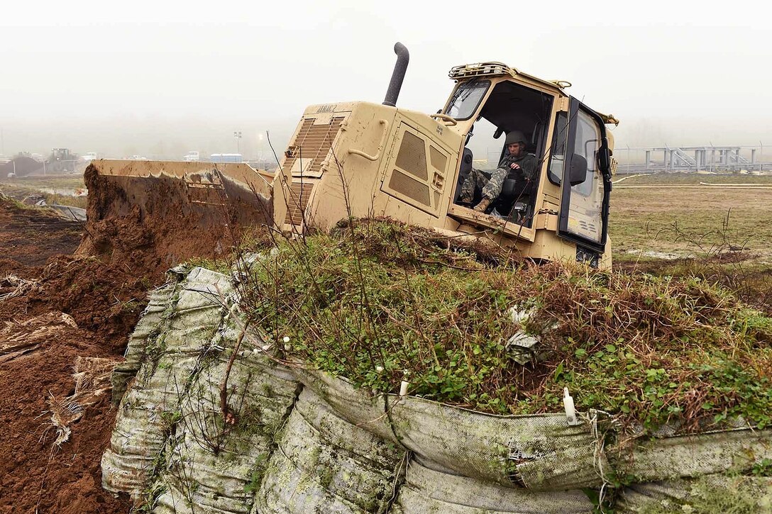 Army Pfc. Austin Burdette repairs a levee in advance of expected river flooding in Krotz Springs, La., Jan. 8, 2016. Burdette is assigned to the Louisiana National Guard’s 769th Brigade Engineer Battalion, 256th Infantry Brigade Combat Team. Louisiana Air National Guard photo by MSgt. Toby Valadie