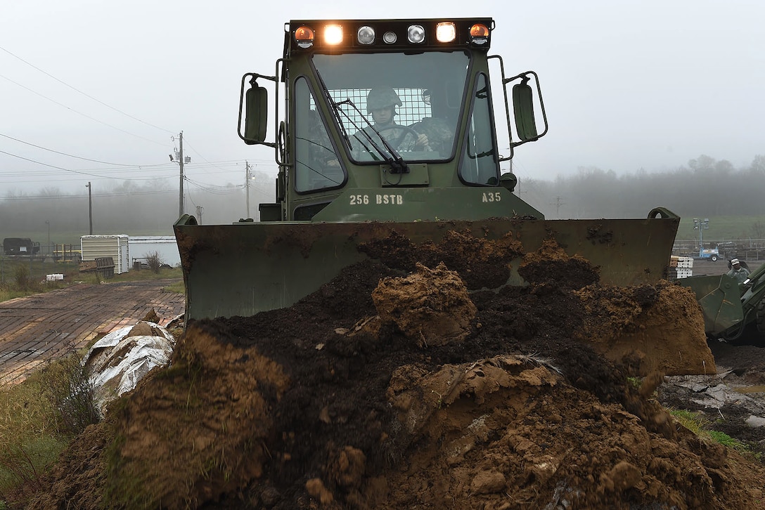 Army Pvt. Taner Mansur operates a M105 deployable universal combat earthmover to repair a levee in advance of expected river flooding in Krotz Springs, La., Jan. 8, 2016. Mansur is assigned to the Louisiana National Guard’s 769th Brigade Engineer Battalion, 256th Infantry Brigade Combat Team. Louisiana Air National Guard photo by MSgt. Toby Valadie
