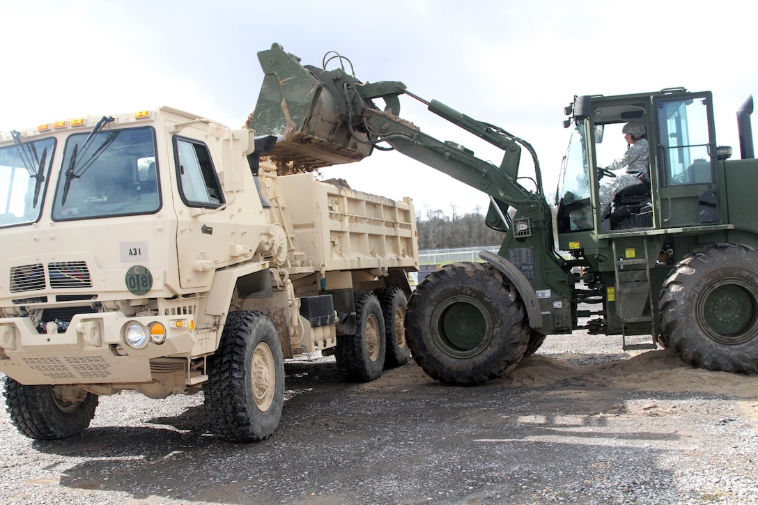 Army Staff Sgt. James P. Cropley operates a bull dozer and dumps a load of sand in the back of a truck to help build protective flood barriers in support of Operation Winter River Flooding in Krotz Springs, La., Jan. 8, 2016. Cropley is a wheeled-vehicle mechanic assigned to the Louisiana National Guard’s 769th Brigade Engineer Battalion, 256th Infantry Brigade Combat Team. Louisiana Army National Guard photo by Spc. Tarell J. Bilbo