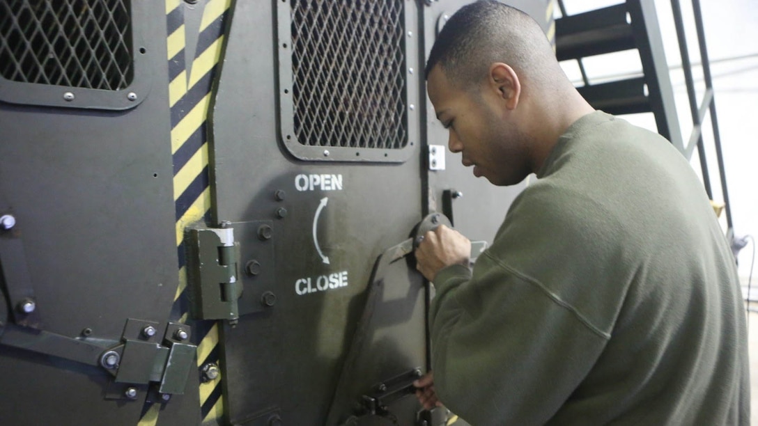 Sgt. Heley Brown, an instructor the Humvee Egress Assistance Trainer Course secures all the doors of the Humvee Egress Assistance Trainer at Marine Corps Base Camp Lejeune, N.C., Jan. 7, 2015. The Marines were taught about the dangers and how to react during Humvee rollovers. 