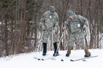 Pvt. Patrick Morris, A Company, 3rd Battalion, 172nd Infantry Regiment (Mountain) works with Capt. Kevin Elmer, logistics officer, A Company, 3rd Battalion, 172nd Infantry Regiment (Mountain) on how to position his skis and hold his ski poles at Bolton Valley Ski Resort, Bolton, Vermont, Jan. 9, 2016. 