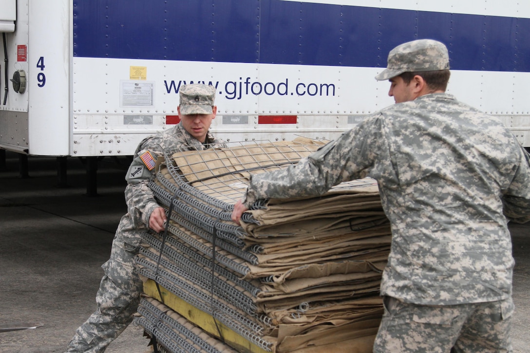 Soldiers load HESCO barriers onto a light medium tactical vehicle for constructing a 12,550-foot long levee on Avoca Island in St. Mary Parish ahead of anticipated river flooding in Morgan City, La., Jan. 8, 2016. The Louisiana National Guard mobilized more than 250 personnel to build protective barriers against potential flood waters and to patrol levees. Louisiana Army National Guard photo by Spc. Garrett Dipuma