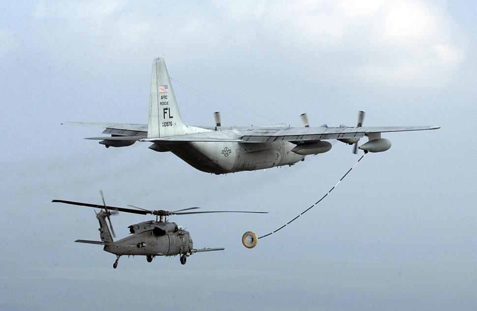 PATRICK AIR FORCE BASE, Fla. – Crews from the 920th Rescue Wing here, prepare to refuel an HH-60G Pave Hawk helicopter from an HC-130P/N aircraft number 65-00976. On Sept. 9, 2015, aircraft #00976 headed to retirement at the 309th Aerospace Maintenance and Regeneration Group, Davis-Monthan Air Force Base, Arizona, the aircraft retirement "bone yard." For nearly 50 years, this combat proven aircraft served the Air Force, providing more than 16,000 hours of superior air support for its Airmen in combat, special operations, humanitarian, aerial refueling, and search and rescue missions around the world. (Courtesy photo)
