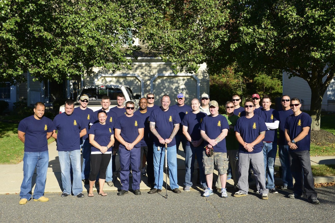 Coast Guard Chief Warrant Officer Richard Sambenedetto poses outside his home in New Jersey with 20 prospective chief petty officers, Oct. 12, 2015. The Coast Guardsmen helped out with landscaping and housework for Sambenedetto, who was diagnosed with myasthenia gravis. U.S. Coast Guard photo by Chief Petty Officer Nick Ameen